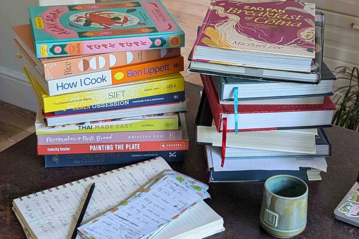 piles of cookbooks on a desk.