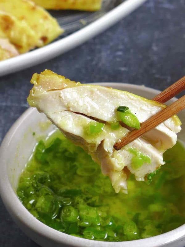 dipping a piece of salt baked chicken into the sauce.