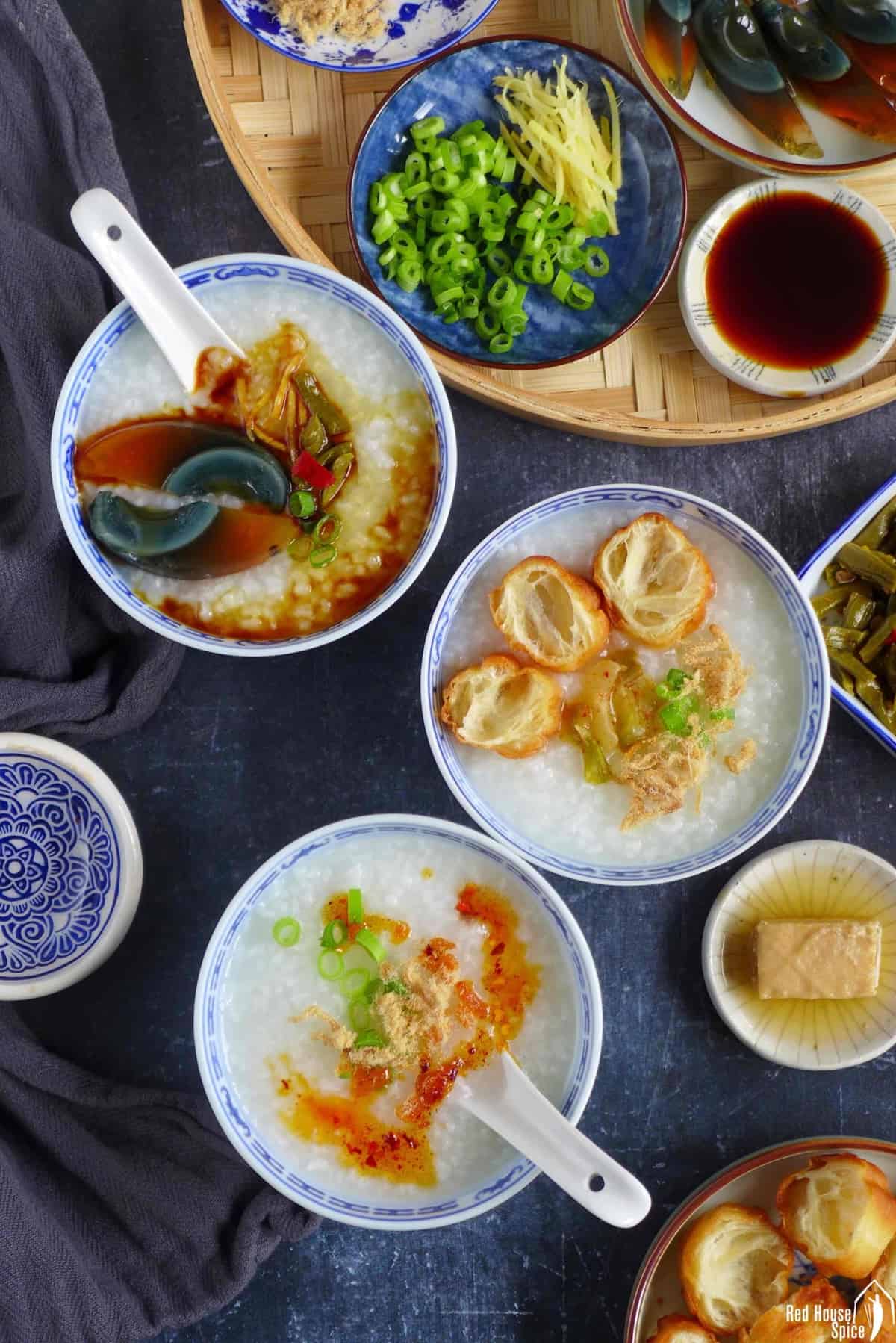 three bowls of plain congee with different toppings
